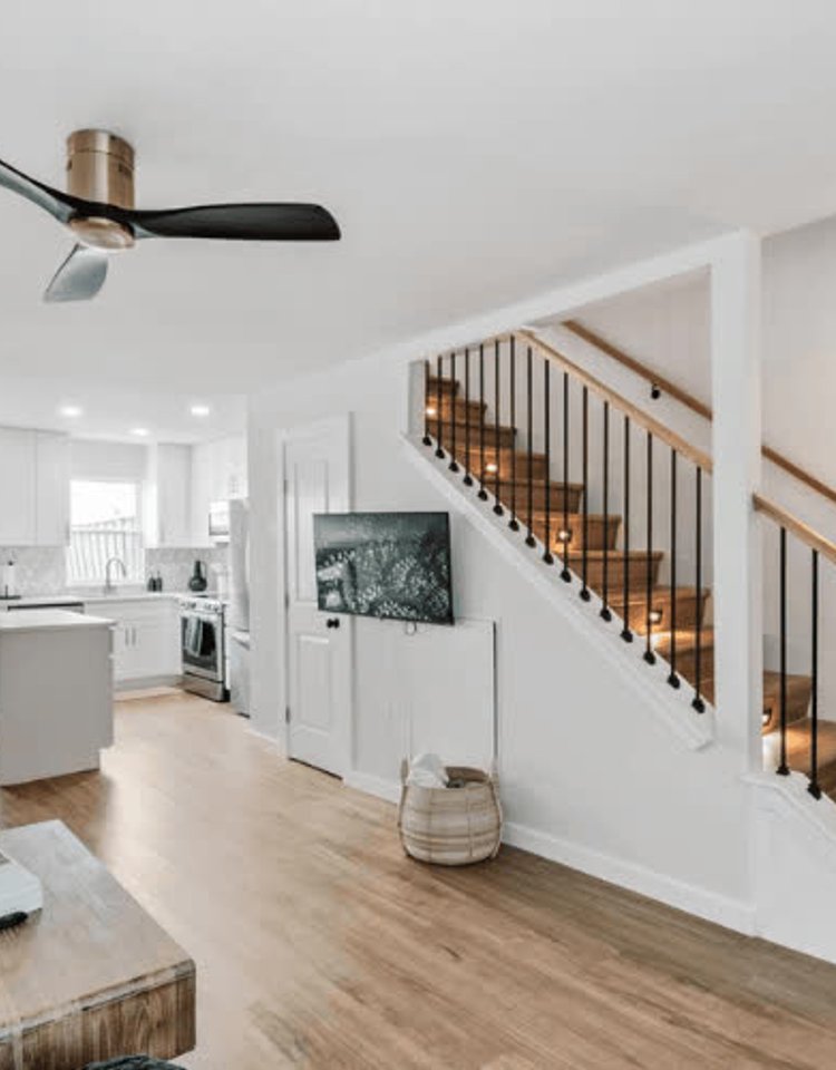 Open-plan interior showcasing a modern staircase and kitchen